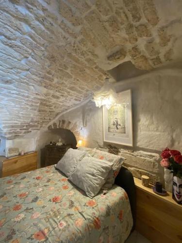 - une chambre avec un lit et un plafond en pierre dans l'établissement Cave de charme 18ème siècle, à Pignan