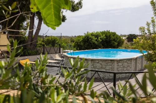a pool with a table and chairs next to it at Aura Solis B&B in Leuca