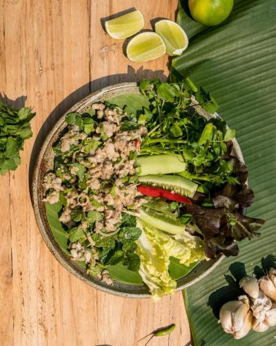 a salad in a bowl on a wooden table at Ock Pop Tok Mekong Villa in Luang Prabang