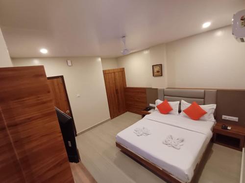 a bedroom with a bed with orange pillows on it at Hotel Elegant in Dimāpur