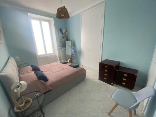 a bedroom with a bed and a chair and a window at La Casa di Gill in Sanremo
