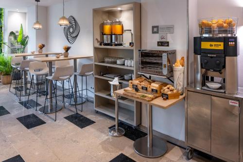 a coffee shop with a counter and stools at Hotel SERHS Del Port in Barcelona
