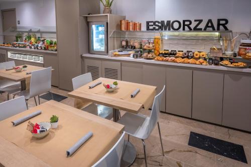 a restaurant with two tables and a counter with food at Hotel SERHS Del Port in Barcelona