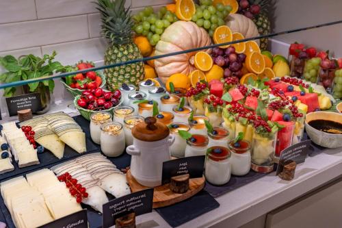 a buffet of cheese and fruit on a table at Hotel SERHS Del Port in Barcelona
