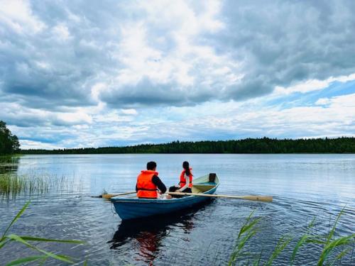 two people in a row boat on a lake at Kätkä Lake Lodge in Tervola
