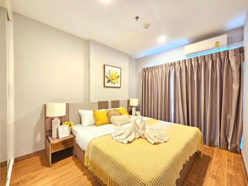 a bedroom with a large bed with yellow pillows at Astra Sky River Chiang Mai by Fang in Chiang Mai