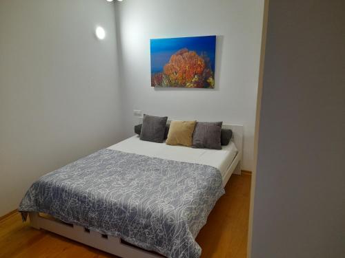 een slaapkamer met een bed en een schilderij aan de muur bij Apartment Dunja in Omiš