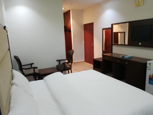 a hotel room with a bed and a television at فندق نيلوفر الهدا الفندقية in Taif