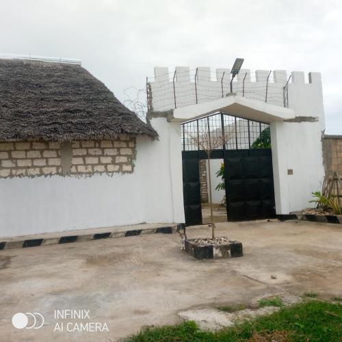 an entrance to a white building with a gate at Rafiki Backpackers-hostel in Nungwi