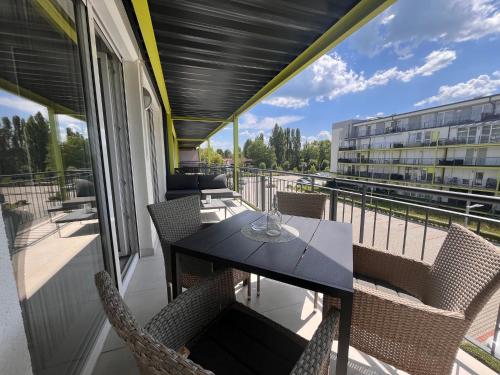 a balcony with a table and chairs and a building at Ale Apartman Siófok in Siófok