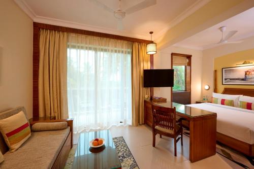 a hotel room with a bed and a desk at Sea Breeze Sarovar Portico Varca Goa in Varca