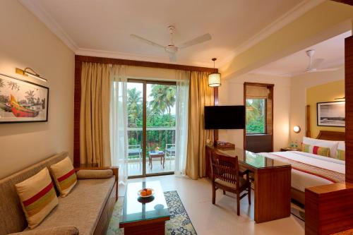 a hotel room with a bed and a couch at Sea Breeze Sarovar Portico Varca Goa in Varca