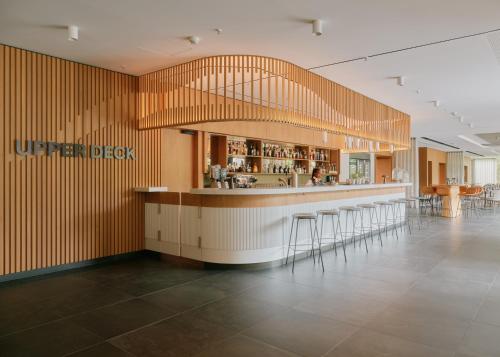 a restaurant with a bar with stools at Lufthansa Seeheim - More than a Conference Hotel in Seeheim-Jugenheim