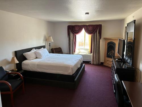 a hotel room with a bed and a fireplace at Super 8 by Wyndham Rexburg in Rexburg