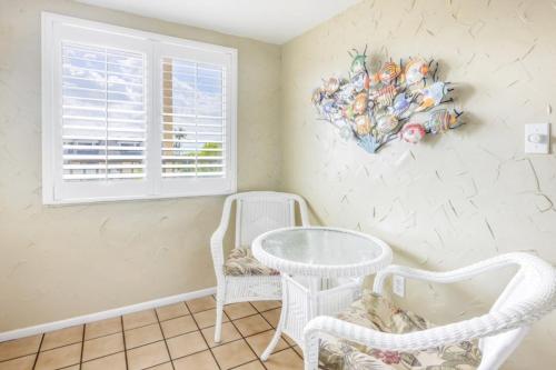 a room with two chairs and a table and a window at Loggerhead 424 condo in Sanibel