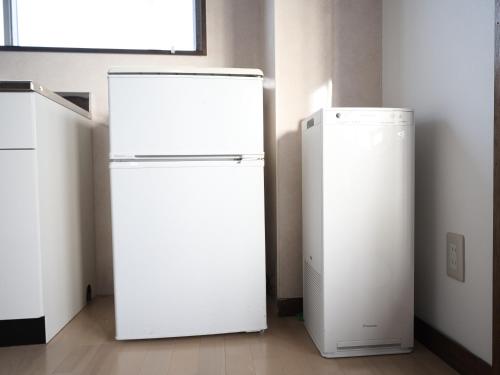 a white refrigerator in a room next to a window at Okasan Hotel in Ogaki