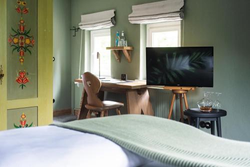 a bedroom with a bed and a desk with a television at Landhaus Flottbek Boutique Hotel in Hamburg
