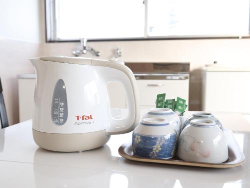 a white mixer sitting on a counter next to jars at Okasan Hotel in Ogaki