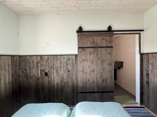 a bedroom with two beds and a wooden door at Kihnu Sadama Öömaja Guesthouse in Lemsi
