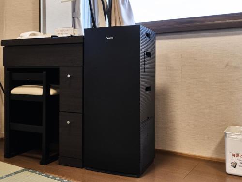 a black computer tower sitting under a desk at Okasan Hotel in Ogaki