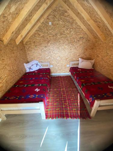 two beds in a room with red sheets at Kucice za odmor in Plav