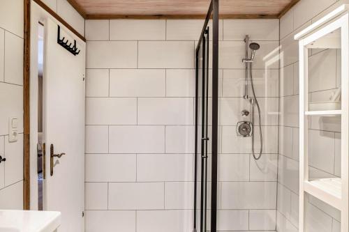 a bathroom with a shower with white tiles at Haus Auner Top 5a in Westendorf