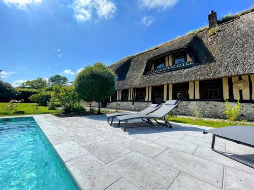 a house with a swimming pool next to a building at La Chaumière Normande in Vattetot-sous-Beaumont