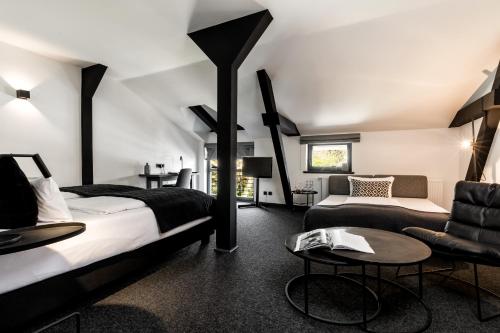 a bedroom with two beds and a couch at Landhaus Flottbek Boutique Hotel in Hamburg