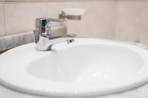 a bathroom sink with a silver faucet at GuestReady - Back to Tullins in Leça da Palmeira