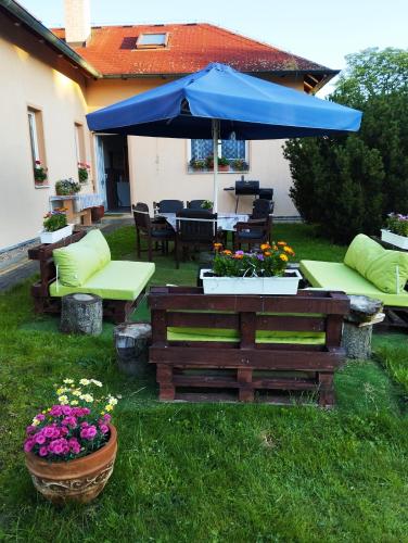 a patio with a table and a blue umbrella at Ubytování Poustka in Františkovy Lázně