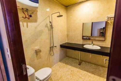 a bathroom with a sink and a toilet and a mirror at Khách Sạn Hoàng Mấm Minh Cầu - Best City view in Thái Nguyên