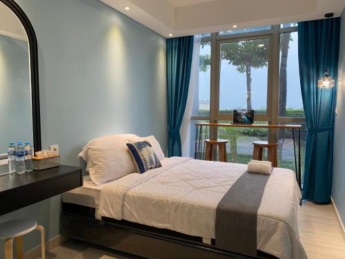 a bedroom with a bed and a large window at Comfort and Luxury Private Room at Goldcoast PIK in Jakarta