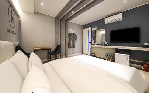 a hotel room with a bed and a television at Heimish Hotel in Tongyeong