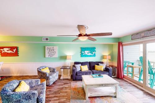 a living room with a couch and a ceiling fan at Summer House West Condos in Gulf Shores