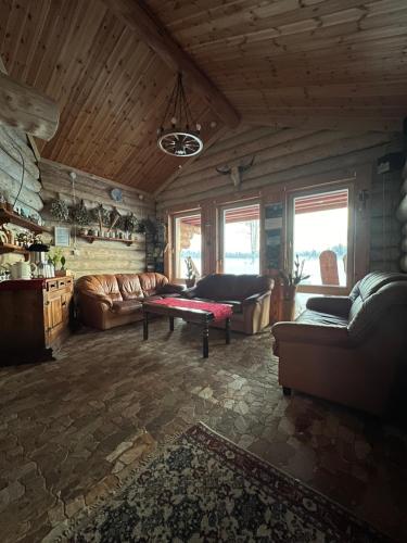 a living room with couches and a table in it at Metsakuurorti puhkekeskus, Mummila house in Saula