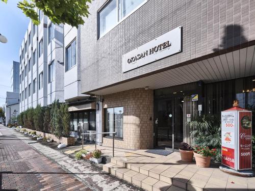 a building with a sign on the front of it at Okasan Hotel in Ogaki