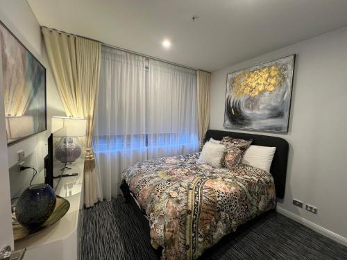 シドニーにあるInner City Luxury Accommodationのベッドと壁に絵が飾られた寝室