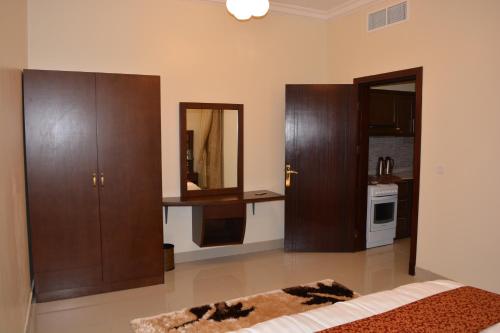 a living room with wooden cabinets and a mirror at Jowharet AlMaseya in Al Khobar