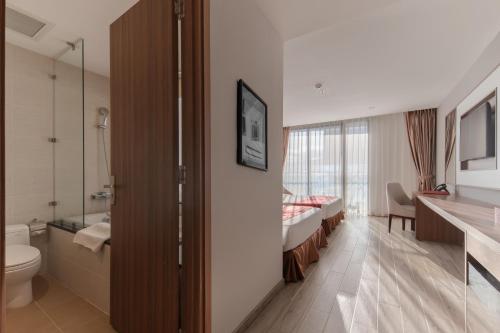 baño con aseo, lavabo y cama en LeMore Hotel Nha Trang, en Nha Trang