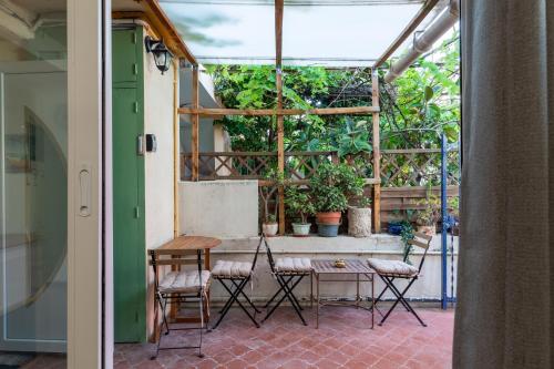 un patio avec une table, des chaises et des plantes dans l'établissement La Succulente - T1 bis climatisé proche plage, à Cannes