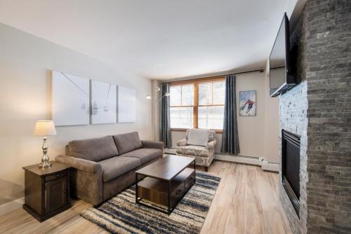 een woonkamer met een bank en een open haard bij Premium Unit 1307 - 1 Bedroom - Zephyr Mountain condo in Winter Park