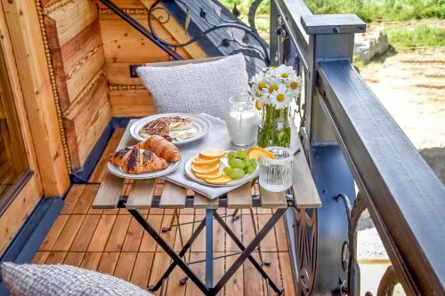 a breakfast of eggs and fruit on a table on a balcony at Osada Góralska Ostoja Pod Gubałówką z Jacuzzi in Zakopane