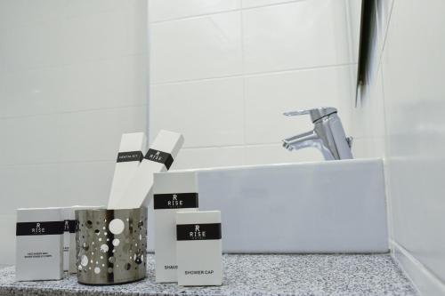 a bathroom with a sink and some boxes on a counter at Rise Urban Art Hotel in Larnaka