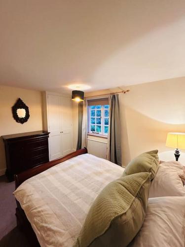 a bedroom with a large bed and a window at Cottage K in Hinxton