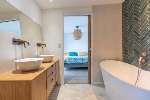 La salle de bains est pourvue de 2 lavabos, d'une baignoire et d'un lit. dans l'établissement Villa Privée au Cœur du Luberon - Piscine Jardin, à Pertuis