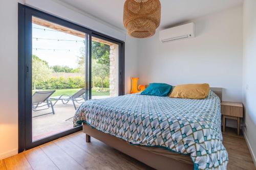 une chambre avec un lit et une grande fenêtre dans l'établissement Villa Privée au Cœur du Luberon - Piscine Jardin, à Pertuis