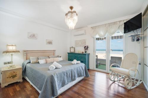 Un dormitorio con una cama y una silla y una ventana. en Atardecer Beach Apartment, en Cádiz