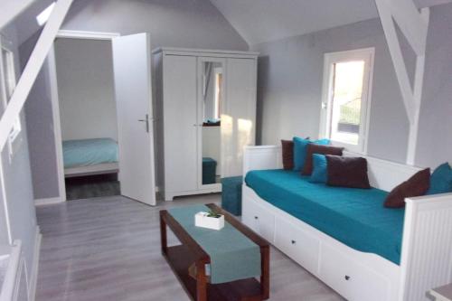 un salon avec un canapé bleu dans une pièce dans l'établissement Longère en bois à 15 min de la mer, à Bretteville-Saint-Laurent