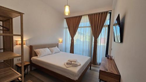 a bedroom with a bed and a large window at Pension Nina in Douăzeci şi Trei August