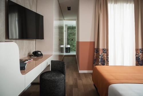 a hotel room with a bed and a television at DuoMo Hotel in Rimini